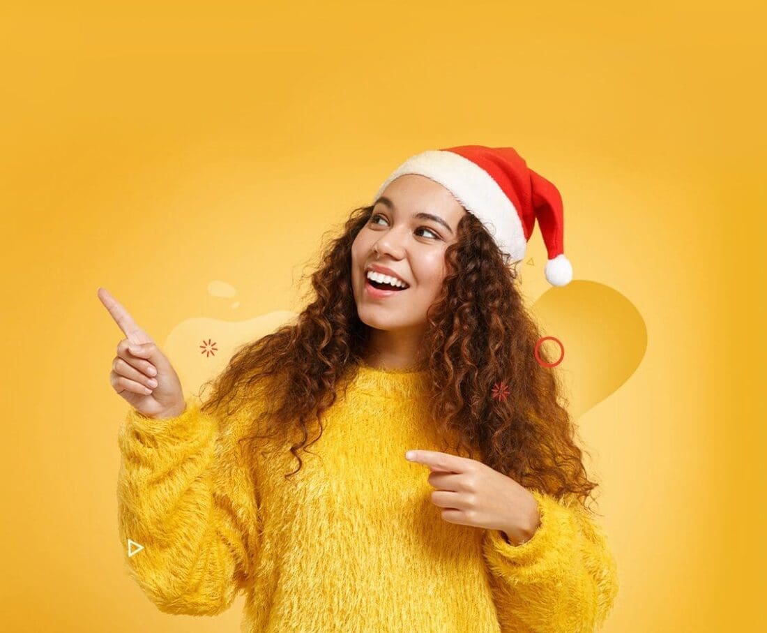 young girl in santa hat pointing to the sky