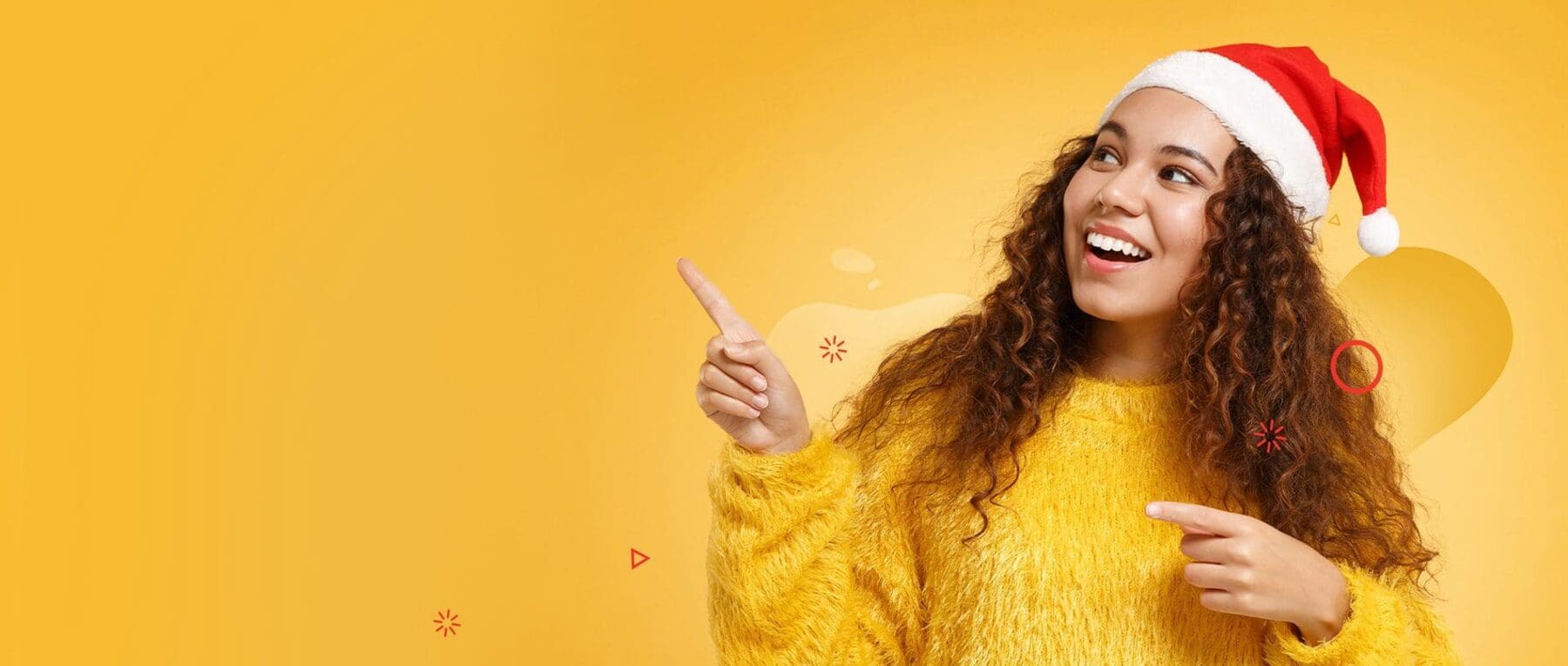 young girl in santa hat pointing up